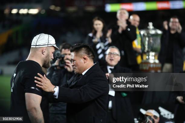 Owen Franks of the All Blacks is presented with his 100th cap from Keven Mealamu during The Rugby Championship game between the New Zealand All...