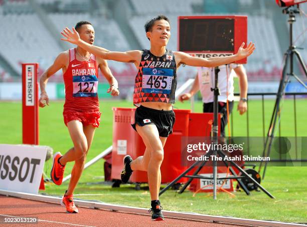 Hiroto Inoue of Japan crosses the finish line to win the Men's Marathon ahead of Elhassan Elabbassi of Bahrain at the GBK Main Stadium on day seven...