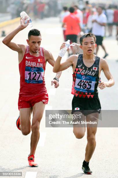 Hiroto Inoue of Japan and Elhassan Elabbassi of Bahrain compete in the Men's Marathon on day seven of the Asian Games on August 25, 2018 in Jakarta,...