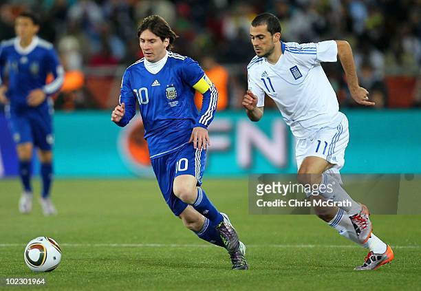 Lionel Messi of Argentina is pursued by Loukas Vyntra of Greece during the 2010 FIFA World Cup South Africa Group B match between Greece and...