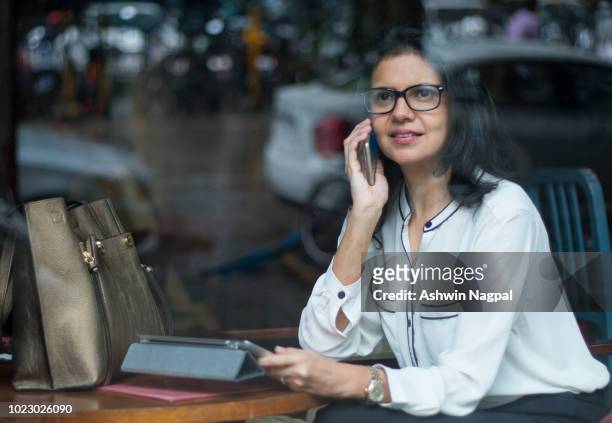 Corporate woman talking on mobile in a coffee shop