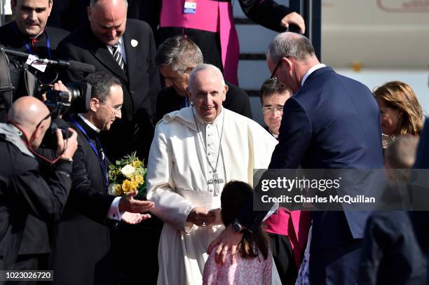 Pope Francis is greeted by Simon Coveney, Irish Minister for Foreign Affairs and his daughters as he arrives at Dublin Airport on August 25, 2018 in...