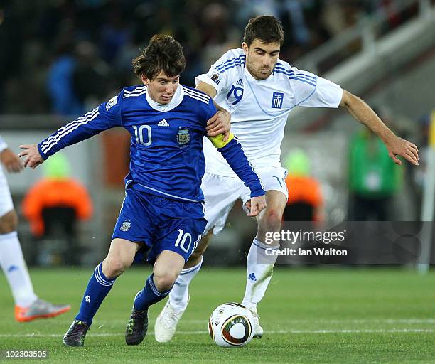 Lionel Messi of Argentina is tackled by Sokratis Papastrathopoulos of Greece during the 2010 FIFA World Cup South Africa Group B match between Greece...