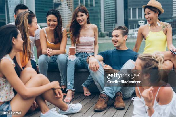 young people chatting outdoors - medium group of people stock pictures, royalty-free photos & images