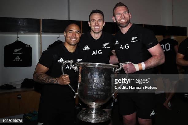 Aaron Smith, Ben Smith and Kieran Read of the All Blacks hold the Bledisloe Cup in the dressing room after winning The Rugby Championship game...