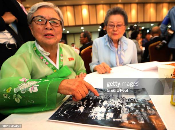 North Korean Ahn Se-Min shows her family photo during a separated family reunion meeting at the Mount Kumgang resort on August 25, 2018 in Mount...