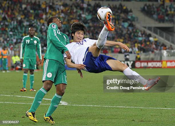 Ki Sung-Yueng of South Korea attempts an overhead kick as Kalu Uche of Nigeria tries to get out of the way during the 2010 FIFA World Cup South...