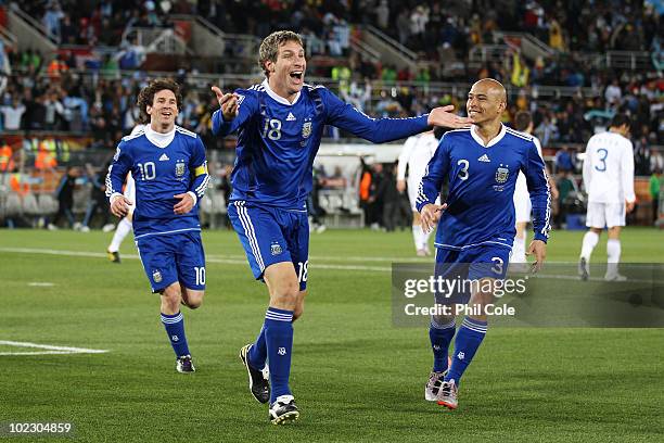 Martin Palermo of Argentina celebrates scoring the second goal with team mates Lionel Messi and Clemente Rodriguez during the 2010 FIFA World Cup...
