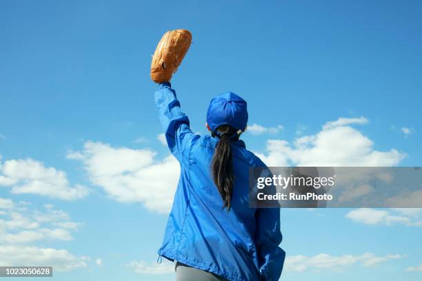 woman looking up sky with baseball glove - woman catching stock pictures, royalty-free photos & images