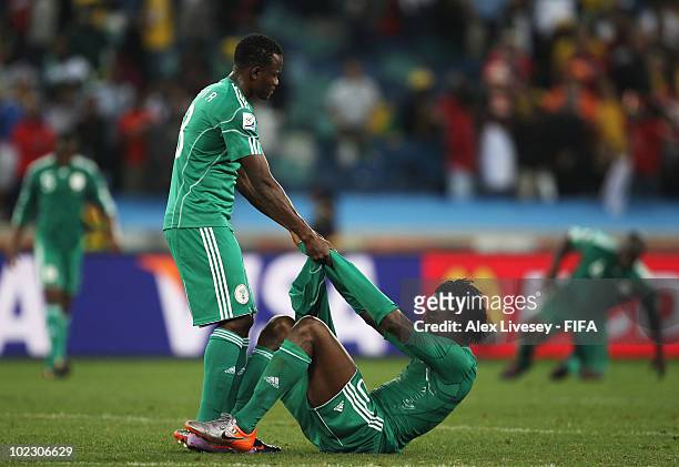 Victor Obinna of Nigeria pulls a dejected Dickson Etuhu of Nigeria off the ground as Nigeria fail to qualify for the next round after a 2-2 draw in...