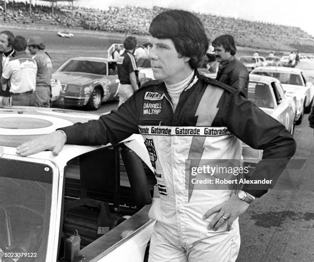 Driver Darrell Waltrip stands beside his racecar prior to the start of the 1980 Daytona 500 stock car race at Daytona International Speedway in...