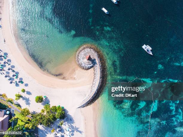 bali kust met een luchtfoto van figuratieve golfbreker - bali stockfoto's en -beelden