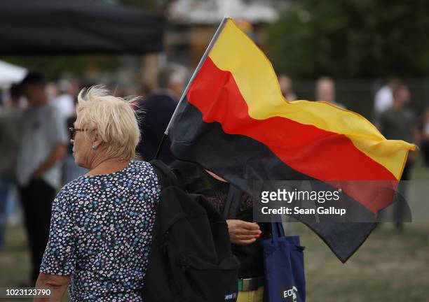 Woman carries a German flag with its colors in reverse order, which she said was on purpose and in reference to the 1832 Hambach Festival, which...