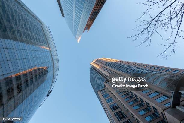 view looking up to bright blue sky between sydney downtown office buildings in evening light - sydney architecture stock pictures, royalty-free photos & images