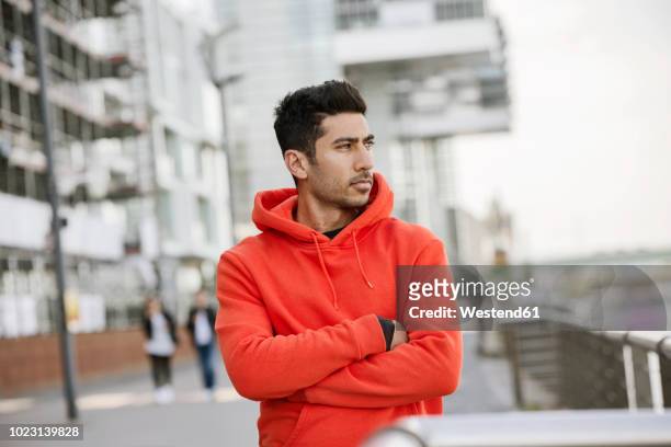 portrait of fashionable young man wearing red hooded jacket - kapuzenoberteil stock-fotos und bilder