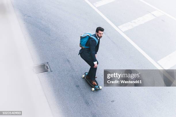 businessman riding skateboard on the street - longboard stock-fotos und bilder