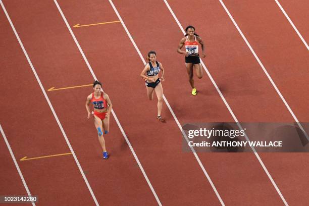 China's Huang Guifen, Vietnam's Thi Hang Nguyen and Bahrain's Iman Essa compete in a heat of the women's 400m athletics event during the 2018 Asian...