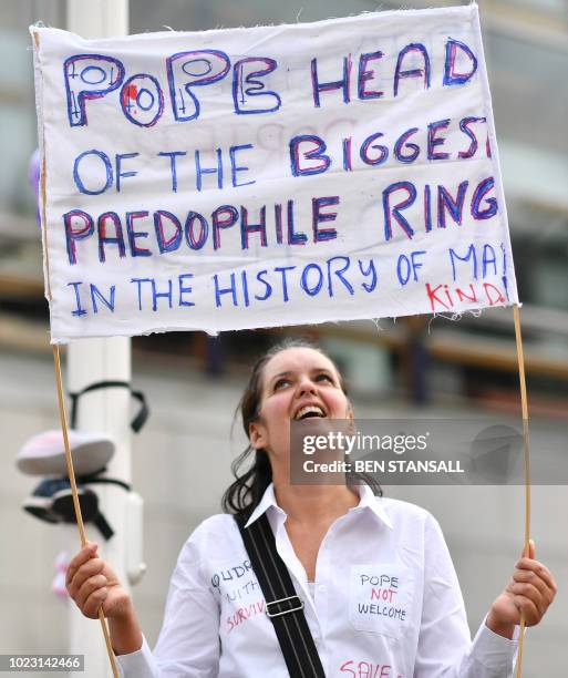 Protestor holds up a banner to demonstrate against abuse in the Catholic church on August 25, 2018 during the visit of Pope Francis to Ireland to...