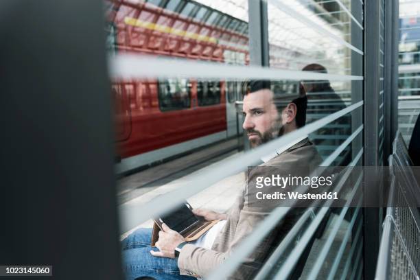 young man with tablet waiting at the station platform - railroad station ストックフォトと画像