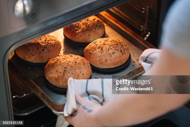 woman taking homemade vegan burger rolls out of oven - ugn bildbanksfoton och bilder