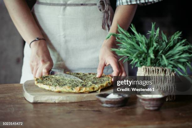 young woman slicing homemade chickpea and herb cake - quiche stock pictures, royalty-free photos & images