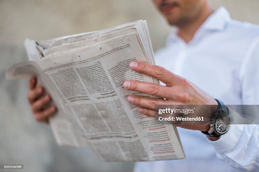 Close-up of businessman reading newspaper