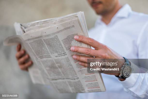 close-up of businessman reading newspaper - periodico fotografías e imágenes de stock