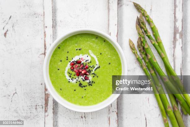 green asparagus soup with pomegranate seeds and black sesame - soep stockfoto's en -beelden