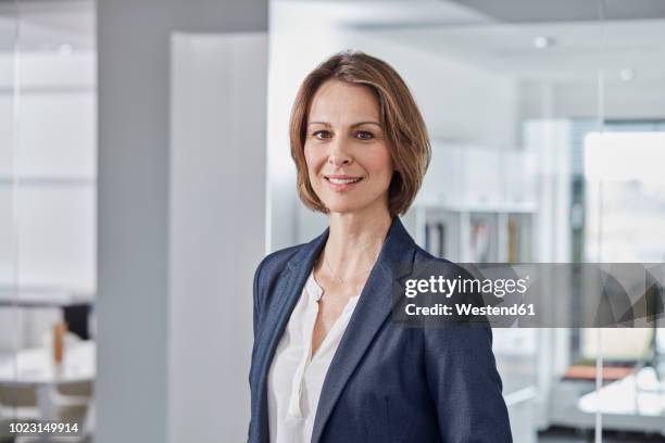 portrait of confident businesswoman in office - one woman only 45 49 years stock pictures, royalty-free photos & images