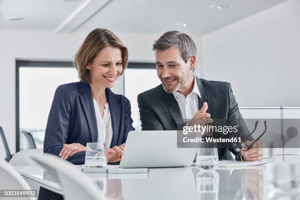 businessman and businesswoman having a meeting in office with laptop - woman business desk front laptop office fotografías e imágenes de stock