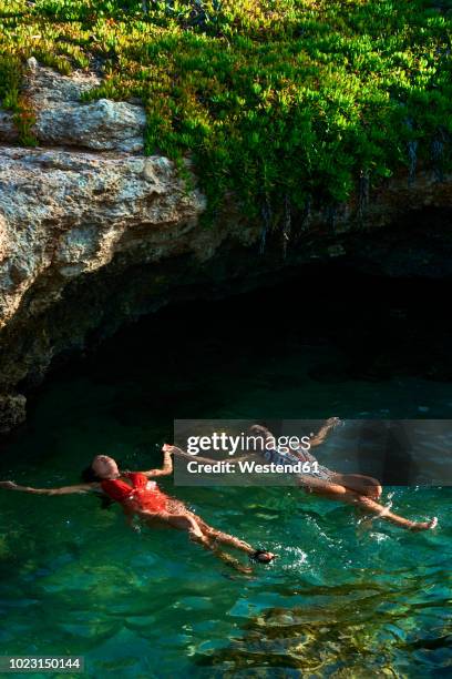 young women floating on water in lagoon - crete woman stock pictures, royalty-free photos & images