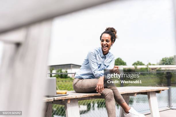 young businesswoman sitting outdoors, taking a break - arbeiten outdoor stadt laptop stock-fotos und bilder