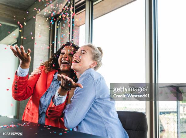 young busniesswomen celebrating success, throwing confetti - celebration stock-fotos und bilder