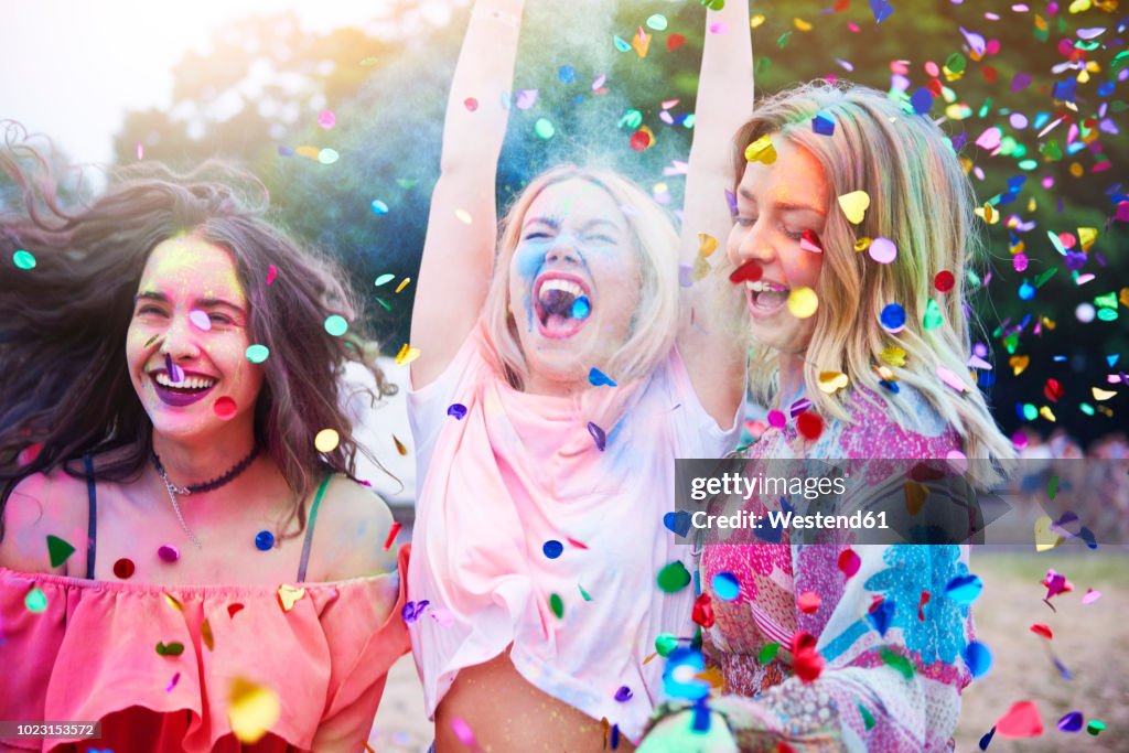 Friends having fun with holi powder and confetti