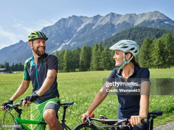 austria, tyrol, mieming, happy couple with mountain bikes in alpine scenery - fun sommer berge stock-fotos und bilder