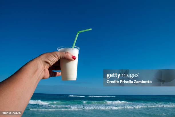 female hand holding piña colada drink - pina colada stock pictures, royalty-free photos & images