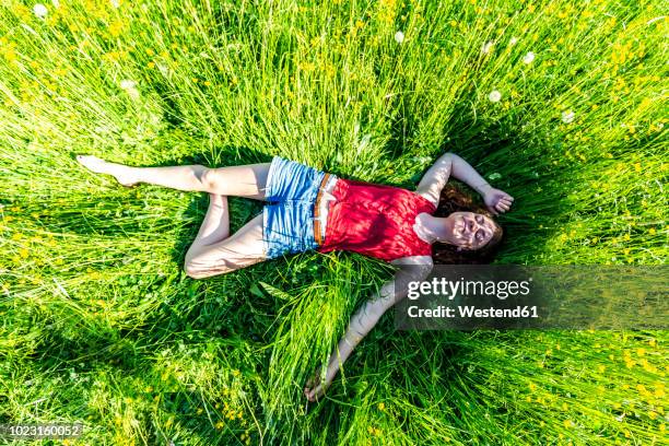 young woman relaxing in meadow - im gras liegen stock-fotos und bilder