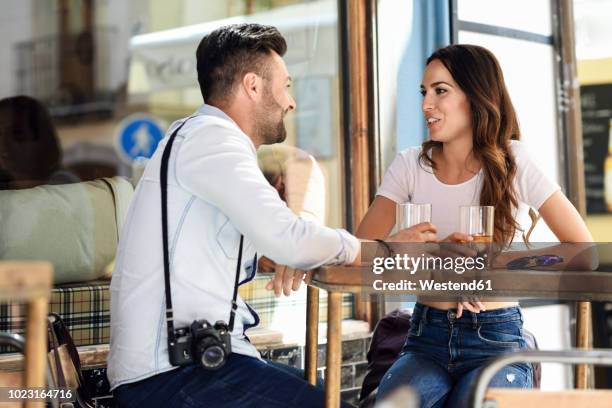 couple having a drink at an outdoor bar in the city - flirten stockfoto's en -beelden