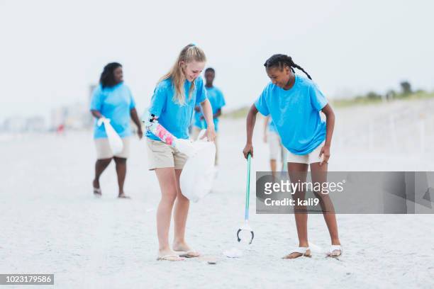 freiwillige abholung müll vom strand - us girls on the beach stock-fotos und bilder