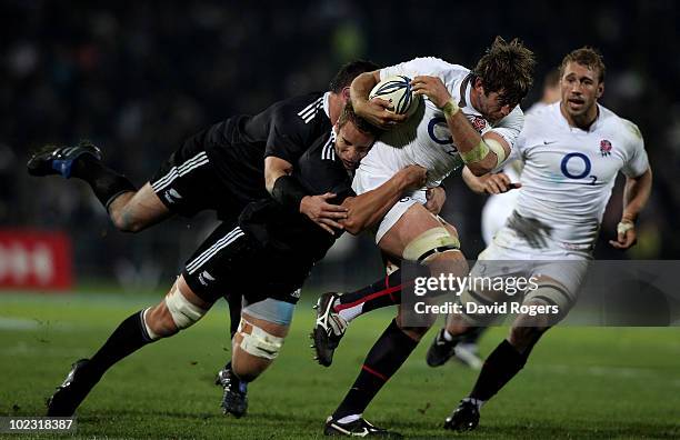 Geoff Parling of England is held by Jarrad Hoeta and Corey Flynn during the international rugby match between the New Zealand Maori and England at...