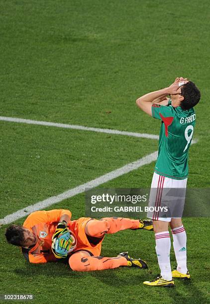Mexico's striker Guillermo Franco reacts after a missed chance on goal as Uruguay's goalkeeper Fernando Muslera holds onto the ball during their...