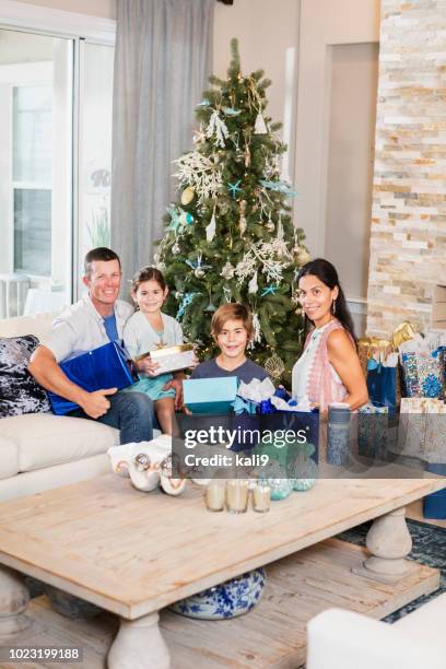 familie sitzt weihnachtsbaum mit geschenken - florida christmas stock-fotos und bilder