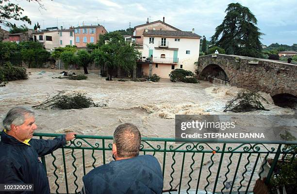 People look at Nartuby river in flood in the aftermath of flooding in a western district of the French south eastern city of Trans-en-Provence on...