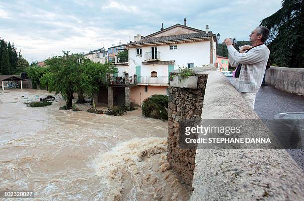 People look at Nartuby river in flood in the aftermath of flooding in a western district of the French south eastern city of Trans-en-Provence on...