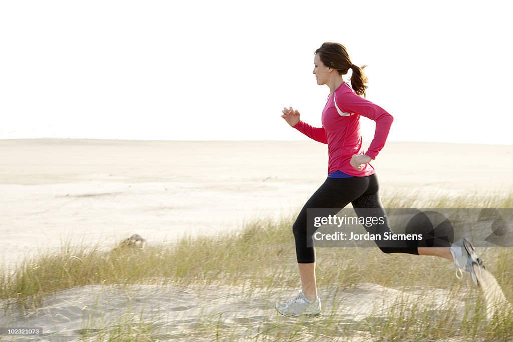 Woman trail running along the Oregon coast. 