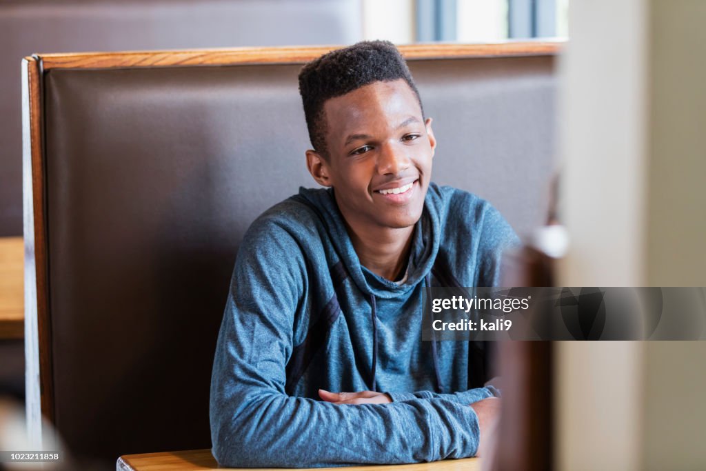レストラン ブースでアフリカ系アメリカ人の 10 代の少年