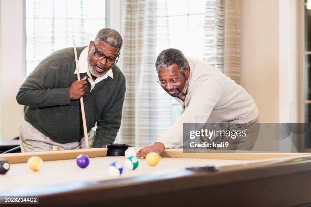 two african-american men playing billiards - billiard ball game stock pictures, royalty-free photos & images