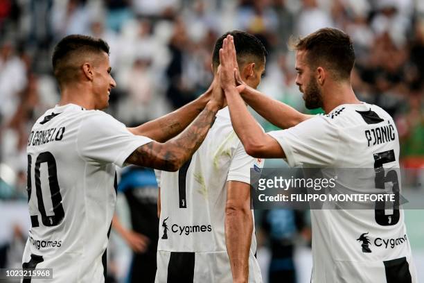 Juventus' Portuguese defender Joao Cancelo, Juventus' Portuguese forward Cristiano Ronaldo and Juventus' Bosnian midfielder Miralem Pjanic celebrate...