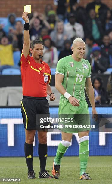 Belgian referee Frank De Bleeckere gives a yellow card to Algeria's midfielder Hassan Yebda during their Group C first round 2010 World Cup football...