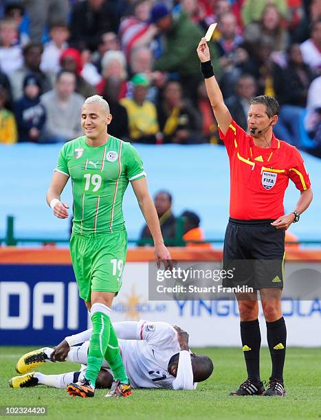 Hassan Yebda of Algeria receives a yellow card from referee Frank de Bleeckere after a tackle on Jozy Altidore of the United States during the 2010...